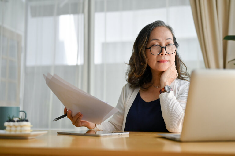 Concentrated asian middle aged female businesswoman using portable computer long term planning horizon elder law