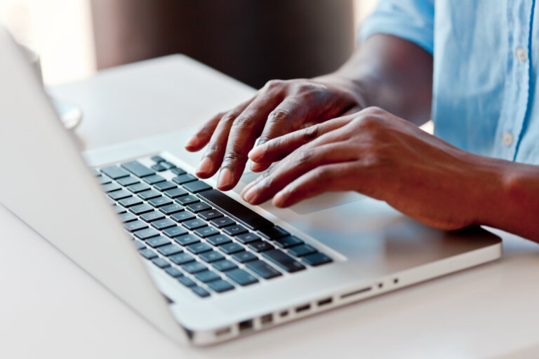 Close-up on male hands typing on laptop keyboard. horizon elder law Avoid Estate Planning Fraud