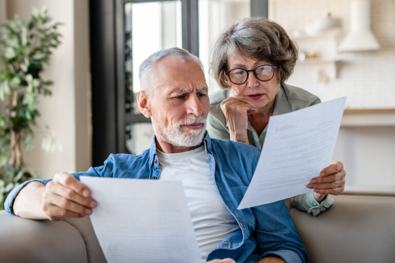 Senior old elderly spouses grandparents reading documents, having issue problem debt with money loss, doing paperwork together at home. Mortgage, loan and commerce procedures asset protection horizon elder law